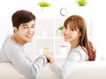 Sweet young couple sitting in sofa