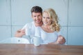 Sweet Young Couple in White Having Morning Coffee