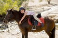 Sweet young girl hugging pony horse smiling happy wearing safety jockey helmet in summer holiday Royalty Free Stock Photo