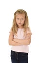 Sweet young schoolgirl with blond hair and folded arms angry upset frustrated and unhappy