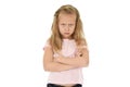 Sweet young schoolgirl with blond hair and folded arms angry upset frustrated and unhappy