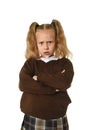 Sweet young schoolgirl in pigtails and school uniform looking angry upset frustrated and unhappy