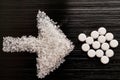 Sweetener tablets lying with sugar on a dark background