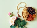 Sweets, dates, dried apricots on a plate on a beige background. Flower.