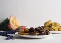 Sweets, dates, dried apricots on a plate. Flower.