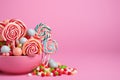 Sweets, lollipop, and candy canes on pink background, tempting treats