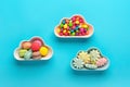 sweets - lollipop, meringues, macaroon in bowl in shape of cloud, chocolate, with colorful topping donut isolated on blue Royalty Free Stock Photo