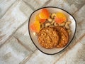 Sweets and nuts on a small rectangular plate, oatmeal cookies and heart-shaped marmalade