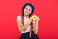 Sweets shop and bakery concept. Kid fan of baked donuts. Delicious sweet donut. Girl in beret hat hold donut red