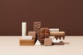 Sweets still life. Composition of sweets: biscuit, candy bar, chocolate, cookie and waffle on a beige and brown background.