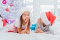 Little sweettooth siblings tasting delicious candies, enjoying the moment,  over white new year background. Royalty Free Stock Photo