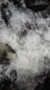 The swift fall of the water makes the river filled with beautiful foam with stones on the surface of the river Royalty Free Stock Photo