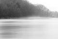 Swift moving river with soft rising mist near shore, bare winter Royalty Free Stock Photo