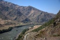 The swift turquoise river flows through the valley in the fusion of mountain ranges Royalty Free Stock Photo