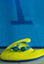 Swim board with Goggles on beside of the swimming pool in sports center. swimming training concept. vertical copy space Royalty Free Stock Photo