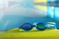 Swim board with Goggles on beside of the swimming pool in sports center. swimming training concept. copy space for text. Royalty Free Stock Photo