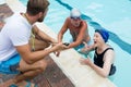 Swim coach interacting with senior couple