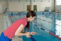 Swim coach looking at stopwatch near poolside at the leisure center