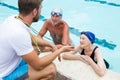Swim coach showing stop watch to senior couple