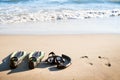 Swim flippers with snorkel, mask and feet steps on a sandy beach. Water sports. Snorkeling. Travel and holiday concept. Fins and s Royalty Free Stock Photo