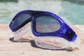 Swim goggles on the edge of a swimming pool