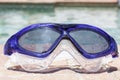 Swim goggles at the edge of a swimming pool