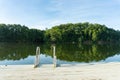 A swim ladder on a dock on Lake Lanier in Georgia with a reflection of green trees in the water