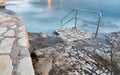 Swim ladder leading to stormy mystic sea Royalty Free Stock Photo