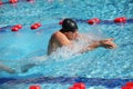 Swimmer in cap breathing performing the breaststroke