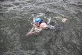 Swimmer in cap and wetsuit performing the breaststroke in dark sea water Royalty Free Stock Photo