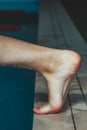 The swimmer pushes off the edge of the swimming pool. Close-up leg before jumping. Cropped image. Stopping in motion Royalty Free Stock Photo