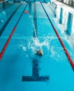 The swimmer pushes off the edge of the swimming pool. woman athlete jumps into the water indoors. Stopping in motion. View from Royalty Free Stock Photo