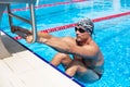 Athletic swimmer on start position in the swimming pool