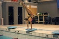 Swimmer, that ready to jump into indoor sport swimming pool. standing on arms with legs up Royalty Free Stock Photo