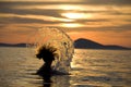 Swimmer splashing at sunset