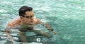 Swimmer. Young athletic brunette man wearing swimming goggles in pool. Panorama banner. Healthy lifestyle. Serious Royalty Free Stock Photo