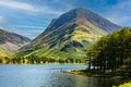 Swimmers on a large, calm lake surrounded by mountains on a hot summers day Royalty Free Stock Photo