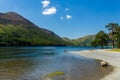 Swimmers on a large, calm lake surrounded by mountains on a hot summers day Royalty Free Stock Photo