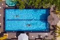 Swimmers man and woman couple diving and swimming in the luxury villa swimming pool. Aerial top shot. Careless summer vacation Royalty Free Stock Photo