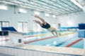 Swimming, action and man diving in pool for training, exercise and workout for competition at gym. Fitness, sports and Royalty Free Stock Photo