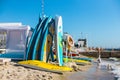 Swimming boards rental. Set of different color surf boards on the beach near the sea or ocean on a sunny day