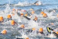 Swimming chaos of male swimmers wearing orange bathing caps