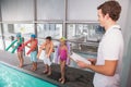 Swimming coach with his students poolside Royalty Free Stock Photo