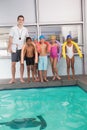 Swimming coach with his students poolside Royalty Free Stock Photo