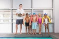 Swimming coach with his students poolside Royalty Free Stock Photo