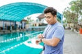 a swimming coach with a stopwatch on his neck standing on a watch