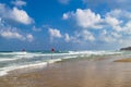 Swimming is dangerous in sea waves. Red warning flag flapping in the wind at stormy weather on the beach Royalty Free Stock Photo