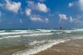 Swimming is dangerous in sea waves. Red warning flag flapping in the wind at stormy weather on the beach Royalty Free Stock Photo