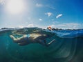 Swimming girl in sunny tropical seashore. Woman swim in blue sea. Snorkeling girl in full-face snorkeling mask. Royalty Free Stock Photo