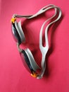 swimming goggles as a tool in swimming sports with a red background